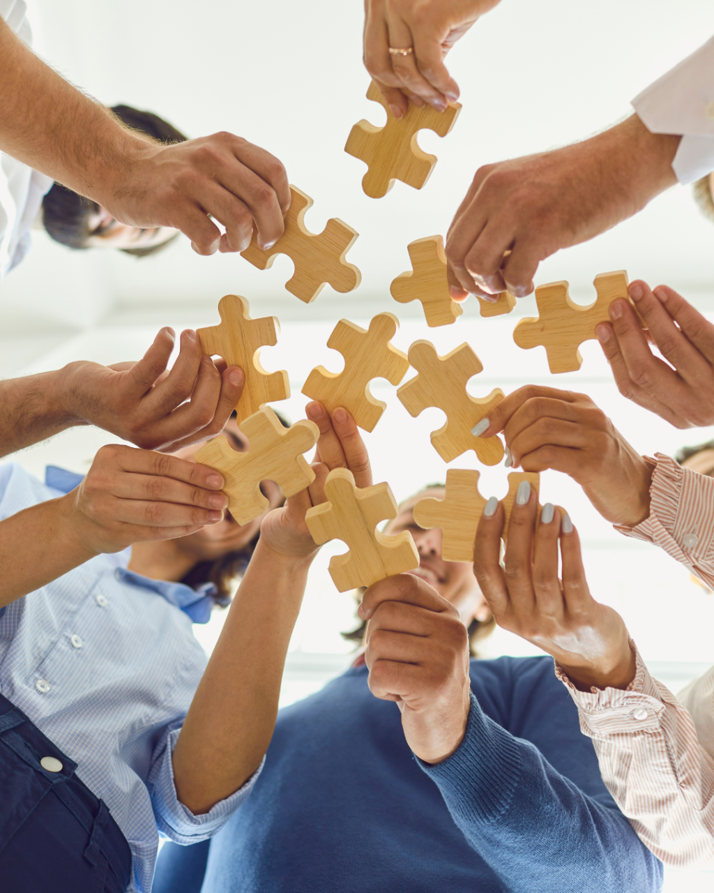 people holding wooden puzzle pieces